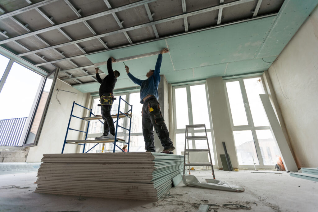construction worker assemble a suspended ceiling with drywall and fixing the drywall to the ceiling metal frame with screwdriver. renovation, construction and do it yourself construction worker assemble a suspended ceiling with drywall and fixing the drywall to the ceiling metal frame with screwdriver. renovation, construction and do it yourself